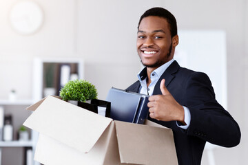 Happy black businessman moving to new office with box and his belongings, showing thumb up, copy...