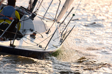 Sailing regatta in the Gulf of Finland at sunset, sailing yacht competing in a race, splashing...