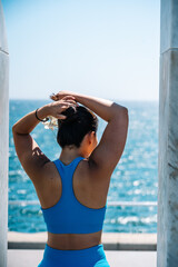 Woman adjusting hair while facing the ocean view
