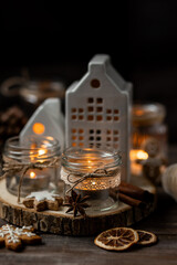 Creative handmade christmas home decor decorations: simple glass jars with aroma candles decorated with a ribbon, cinnamon, anise, dry orange. Cozy atmospheric composition for holiday mood creation