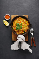 Black pan with red lentil with leek on wooden board on black background. Vegan cuisine. top view , copy space