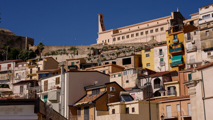 Picturesque view of the colorful houses of Scilla, Calabria, with the Sanctuary of Madonna di Reggio and Ruffo Castle on top, a popular tourist destination in Southern Italy