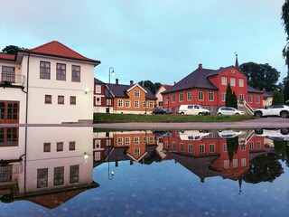 Vibrant building reflections in a street puddle in Larvik, Norway