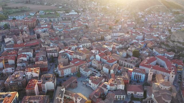 Picturesque drone view of Calatayud cityscape in spring in valley of Iberian mountain area overlooking brownish tiled roofs of residential buildings, Spain
