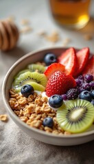 Delicious healthy breakfast bowl muesli granola yogurt berries fresh fruit. Slices of kiwi strawberries, blueberries on top. Tasty morning meal for diet vegan breakfast. White creamy porridge with