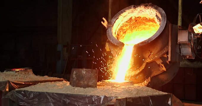 Smelting metal in a metallurgical plant. Liquid iron from metal ladle pouring in castings at factory