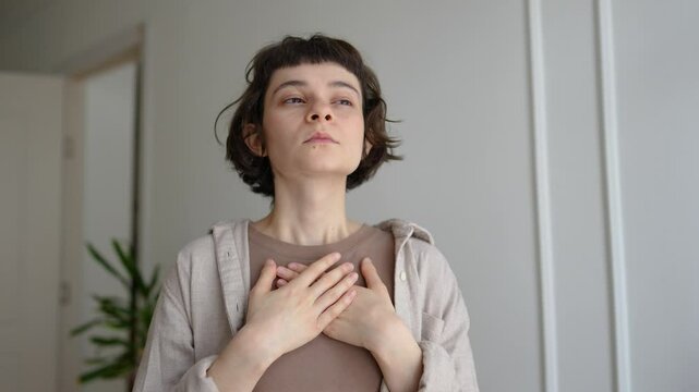 Calm woman in contemplation slow breaths inhaling exhaling with arms on chest, Self centering ritual, stress relief, mindful zen like practice, spiritual intentional breathing, quiet introspection