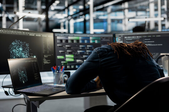 Exhausted server farm engineer falls asleep while looking at data analysis graph to reduce equipment failure. Tired data center worker exhausted after looking at AI visualization dashboard all day - Powered by Adobe