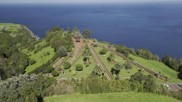 Drone orbits 180 degrees around Miradouro da Ponta do Sossego park and viewpoint on sunny day in Sao Miguel, Azores, Portugal