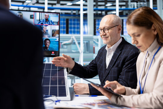Investors in factory office performing financial analysis during videocall to project future investment performance. Shareholders assessing deal feasibility and project returns during teleconference