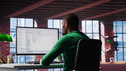 Black IT developer at PC coding and creating an app software, implementing algorithms to fix...