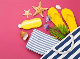 Blue beach bag with summer accessories on color background, top view