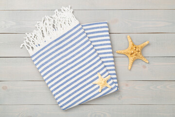 Folded blue beach towel on wooden background,top view