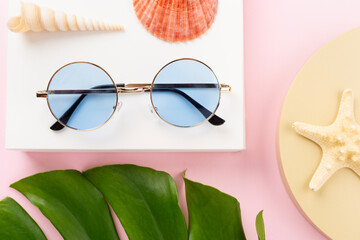 Blue sunglasses on color background, top view