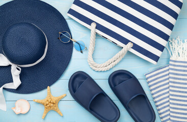 Blue beach accessories on wooden background, top view. Flat lay