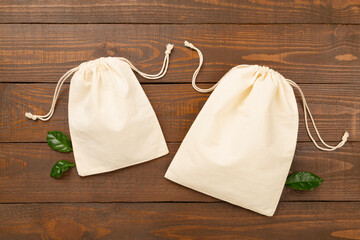 Small eco sacks on wooden background, top view