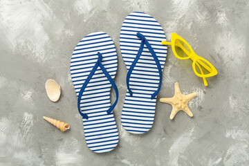 Striped blue flip flops on concrete background, top view