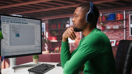 Freelance developer writing code in a modern programming language. Young man analyzes big data,...