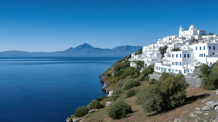 Whitewashed village nestled on a hillside overlooking a tranquil lake and mountains.
