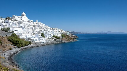 Whitewashed village on a hillside overlooking a clear blue sea.