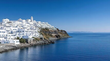 Whitewashed village nestled on a Mediterranean hillside overlooking the ocean.