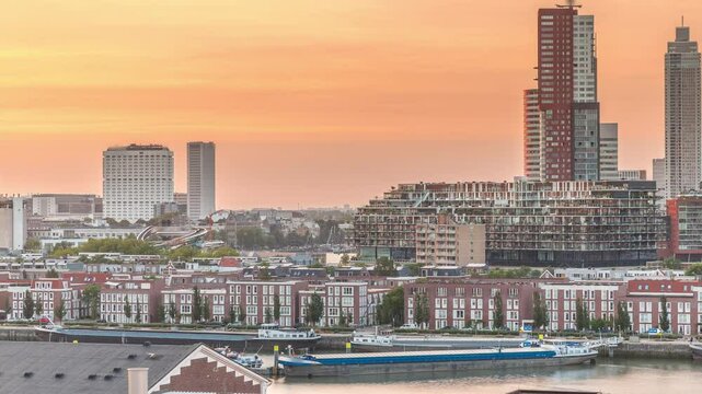Aerial timelapse of modern buildings in Rotterdam city center during sunset, The Netherlands. Towers and skyscrapers in the financial district, former factory with orange sky creating vibrant skyline