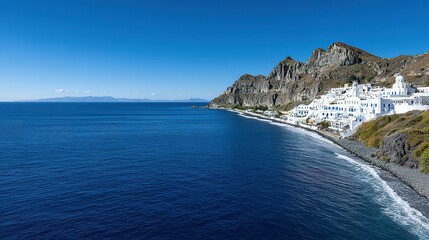 Fototapeta premium Coastal town nestled against a hillside, overlooking a dark-colored beach.