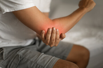 Man with elbow injury showing red highlights pain relief concept concept muscle pain due to lateral epicondylitis or tennis elbow injury, Health care concept	