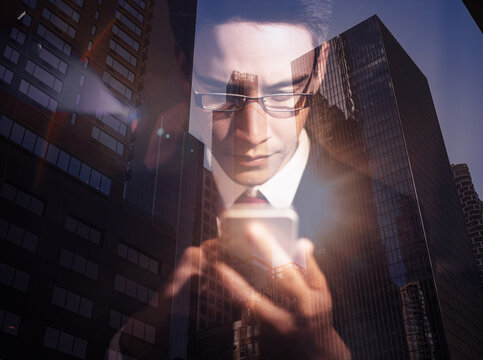 business man using smartphone on city double exposure background