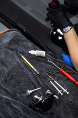 Auto windshield crack repair tools on work surface. Essential tools for windshield crack repair...