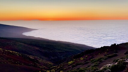 A stunning ocean sunset beautifully lighting up a mountainous landscape filled with wonder