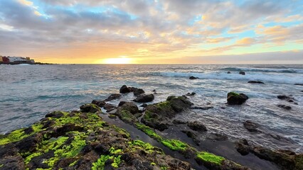 Obraz premium Experience the stunning coastal sunrise over the picturesque rocky shoreline this morning