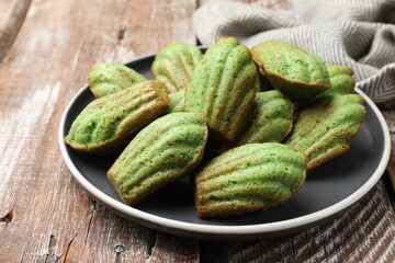 Tasty matcha madeleine cakes on wooden table, closeup