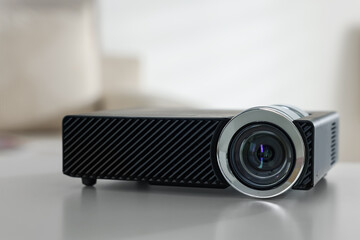 Modern video projector on white table indoors, closeup