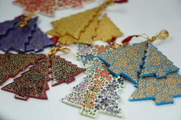 Hand-painted papier-mâché Christmas goodies by Kaar Kash, featuring stars, bells, trees, and more—crafted for hanging on Christmas trees and adding artisanal charm to festive décor.

