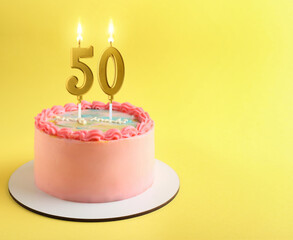 Yummy cake with burning number shaped candles on yellow background, space for text. 50th birthday...