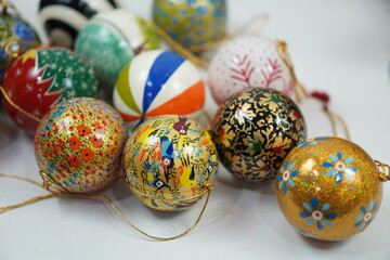 Hand-painted papier-mâché Christmas balls designed for hanging on Christmas trees, combining traditional craftsmanship with festive charm for seasonal decoration.

