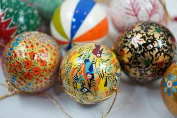 Hand-painted papier-mâché Christmas balls designed for hanging on Christmas trees, combining...