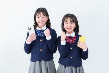 スマートフォンを持ってガッツポーズをする女子学生