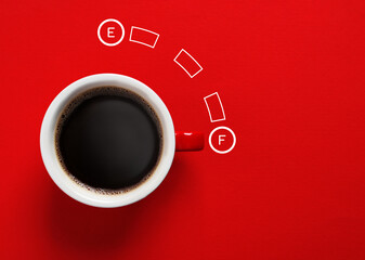 Coffee and fuel gauge scale on red background, top view. Handle of cup pointing at Full mark....