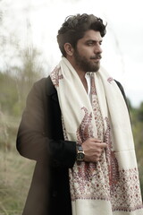 A Kashmiri model dressed in a traditional shawl and vintage-style pheran, posing for a Kaar Kash shoot that highlights timeless craftsmanship and the cultural soul of Kashmir.

