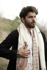 A Kashmiri model dressed in a traditional shawl and vintage-style pheran, posing for a Kaar Kash shoot that highlights timeless craftsmanship and the cultural soul of Kashmir.

