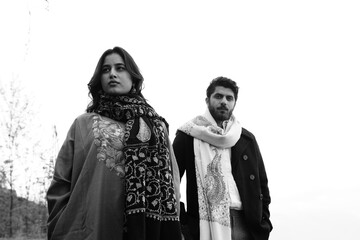 A couple posing in traditional Kashmiri attire, adorned in handwoven shawls and embroidered pherans, showcasing the rich heritage and artistry of Kaar Kash in a styled fashion shoot.


