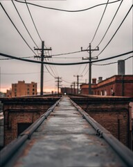 Obraz premium Gritty Rooftop View of Electric Lines Against Dramatic Sky