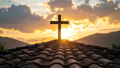 Silhouette of a cross on a rooftop against a sunset backdrop
