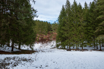 Vedema ski slope covered in snow with a dense pine forest and visible rock face in Hässleholm, Sweden