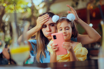 Daughter Taking the Phone of her Mom Playing with it. Desperate mother feeling annoying by the screen addiction of her kid
