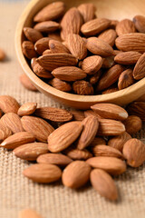 Raw almond nut seed in wooden bowl, Food ingredient
