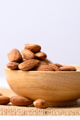 Raw almond nut seed in wooden bowl with white background, Food ingredient