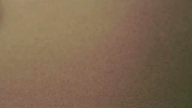 Close-up of colorful construction paper texture with soft, fluctuating shadows creating a subtle, dynamic background loop.